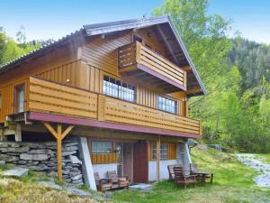 uma grande casa de madeira com uma varanda no topo em Apartment STRYN II em Stryn