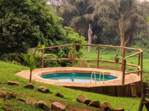 a pool of water with a wooden fence at ViaVia Entebbe in Entebbe