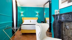 a bedroom with blue walls and a bed and a chair at Hotel The Corner Roma in Rome