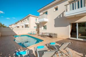 een terras met stoelen en een zwembad bij Protaras Holiday Villa 035 in Protaras