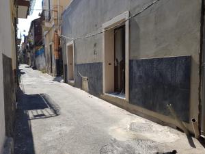 een lege steeg met een gebouw en een deur bij San Damiano Suite in Catania