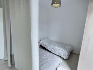 Habitación blanca con cama y lámpara en Studio à 600m de la mer dans une résidence récente, en Sérignan