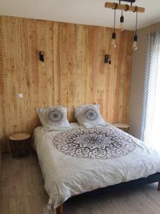 una camera da letto con un grande letto e pareti in legno di Villa de 4 chambres avec piscine privee spa et jardin clos a Prayssac a Prayssac