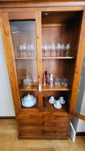 um armário de madeira com copos e pratos em Chiqui Home em Salamanca