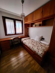 a bedroom with a bed and a desk and windows at Chiqui Home in Salamanca