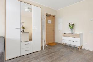 een kamer met een spiegel, een dressoir en een deur bij Studio Aisa 39 in Pärnu