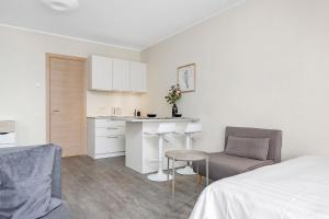 a bedroom with a bed and a kitchen with a table at Studio Aisa 39 in Pärnu