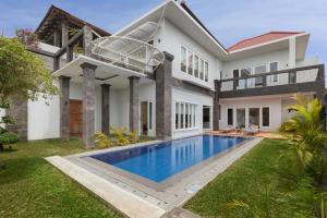 a house with a swimming pool in the yard at Villa Haka Jimbaran by Nagisa Bali in Jimbaran