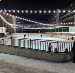 an ice skating rink at night with skaters on it at Bakuriani Crystal Resort in Bakuriani