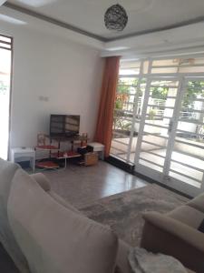 a living room with a couch and a television at Lux suites Utawala Family House in Nairobi +47 photos