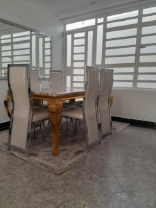 a dining room table with chairs around it at Lux suites Utawala Family House in Nairobi