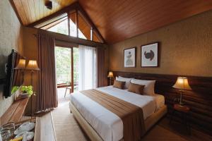 Un dormitorio con una cama grande y una ventana en Taman Wisata Bougenville, en Malabar