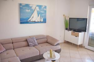 a living room with a couch and a tv at Summer Fun Apartment in Novalja