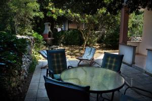 Una mesa de cristal y sillas alrededor de un patio. en Apartment Anita Novalja, en Novalja
