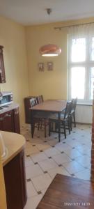 a kitchen with a table and chairs in a room at Ogarna 88 in Gdańsk