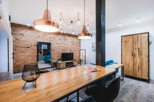 een eetkamer met een houten tafel en een bakstenen muur bij Modern Apartments Toruń 2 in Toruń