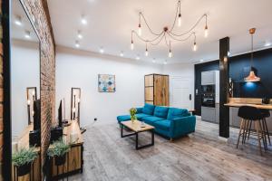 a living room with a blue couch and a table at Modern Apartments Toruń 2 Stare Miasto-Centrum in Toruń