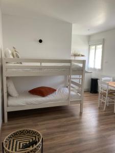 貝葉的住宿－Appart’hôtel saint patrice，客房设有两张双层床和一张桌子。