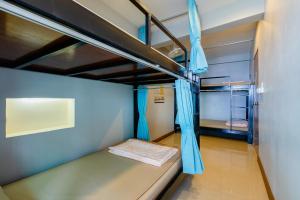 a bunk bed with blue curtains in a room at Restiny Hostel in Bangkok