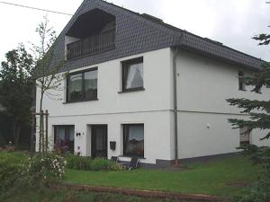ein weißes Haus mit Fenstern und einem Balkon in der Unterkunft Apartment in Eifel near Nürburgring in Oberstadtfeld
