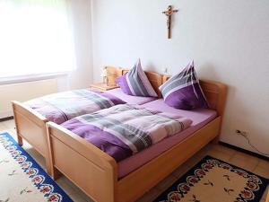 a bed with purple sheets and pillows in a bedroom at Holiday apartment in Oberstadtfeld with garden in Oberstadtfeld