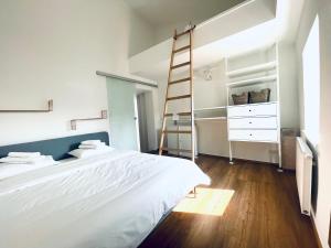 Un dormitorio con una cama blanca y una escalera en MIA Lifestyle Appartements, en Innsbruck
