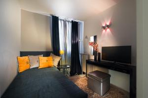 ein Schlafzimmer mit einem Bett mit gelben Kissen und einem TV in der Unterkunft Charming House DD724 in Venedig