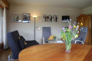 a vase of flowers sitting on top of a wooden table at Scierie A Meya 118 - Appartement charmant proche des télécabines et du village in Vercorin