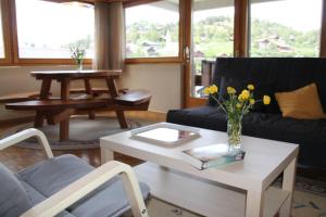 a living room with a couch and a table with flowers at Scierie A Meya 118 in Vercorin