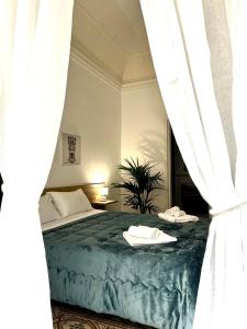 a bed with a white blanket and pillows on top of it at Sicilian Rooms Palermo in Palermo