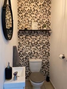 a bathroom with a toilet and a mosaic wall at LOFT DIONYSIEN DE STANDING in Saint-Denis +8 photos
