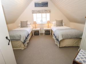 a attic room with two beds and a window at Compton Grange in Newport