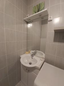 a white bathroom with a sink and a toilet at Studio Cap d'Agde le Môle in Cap d'Agde