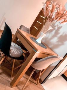 einen Holztisch mit zwei Stühlen und einer Vase in der Unterkunft Apartament Solna 80 - Centrum Miasta z podziemnym garażem in Kielce