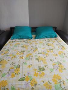 a bed with a blanket with flowers on it at Studio Cap d'Agde le Môle in Cap d'Agde