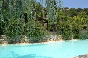 a swimming pool with a stone wall and trees at Casa Espunyes Confort in Oden