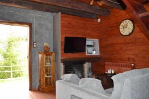 a living room with a fireplace and a clock on the wall at Casa Espunyes Confort in Oden
