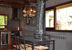 a dining room with a table and chairs and a chandelier at Casa Espunyes Confort in Oden
