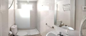 a white bathroom with a toilet and a sink at Apartamento a 5 min de la playa y el centro in Almería