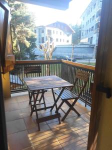 a wooden table and two chairs on a balcony at Apartamento bonito Molina Alp in La Molina
