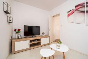 a living room with a television and a table and chairs at Apartment Laura - Lapad in Dubrovnik