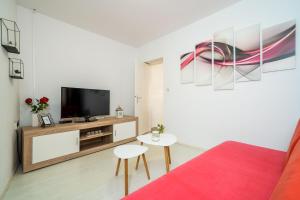 a living room with a tv and a red couch at Apartment Laura - Lapad in Dubrovnik