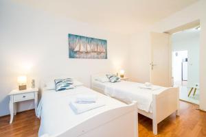 a bedroom with two beds and a table and a mirror at Apartment Laura - Lapad in Dubrovnik