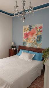 una camera da letto con un letto e un dipinto sul muro di Appartamento - Lì de Là tra i fiori a Villafranca di Verona