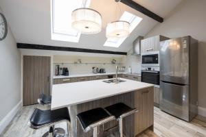 a kitchen with a large island with stools at Harrogate Serviced Apartments - St George's Five in Harrogate