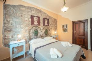 a bedroom with a bed and a stone wall at Taormina Garden Hotel in Taormina