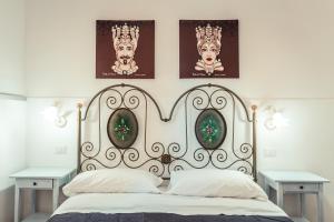 a bedroom with a large white bed with two tables at Taormina Garden Hotel in Taormina