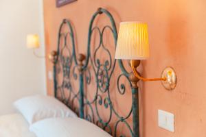 a lamp hanging on a wall next to a bed at Taormina Garden Hotel in Taormina
