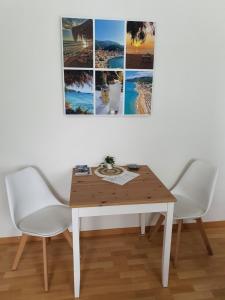 een eettafel met 2 stoelen en een foto aan de muur bij Ferienwohnung Preveza in Kappeln