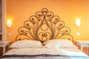 a headboard of a bed in a room with two pillows at Taormina Garden Hotel in Taormina